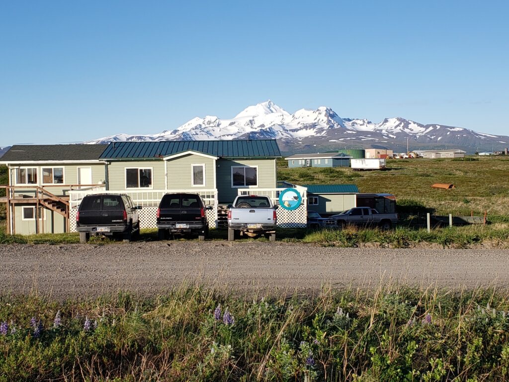 Izembek Lodge exterior with snow-capped mountains